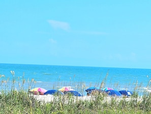 Na praia, espreguiçadeiras, toalhas de praia