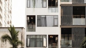 Een gebouw met meerdere verdiepingen, balkons, grote ramen en een vlag.