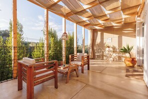 A wooden deck with a pergola, two wooden benches, a table, and chairs. - Laranjal Farm House (Olhao)