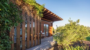 A modern wooden house with a deck, large windows, and a pergola. - Laranjal Farm House (Olhao)