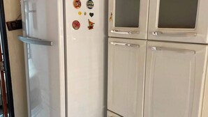 Un réfrigérateur blanc avec un compartiment congélateur situé en haut, un four à micro-ondes et un petit four.