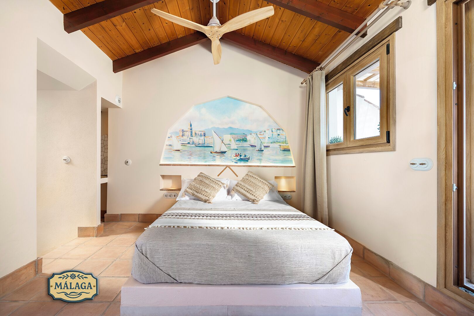 A bedroom with a bed, a ceiling fan, a painting, and a window.