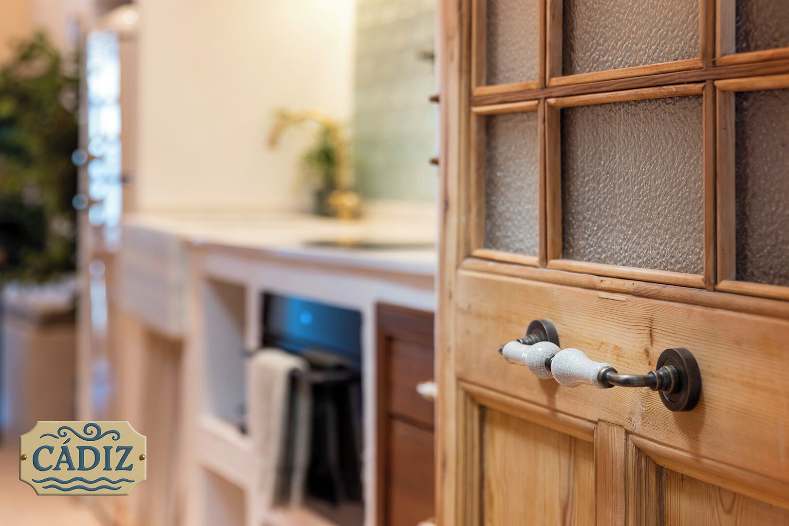 Une porte en bois avec un panneau en verre texturé et une poignée blanche, richement décorée.