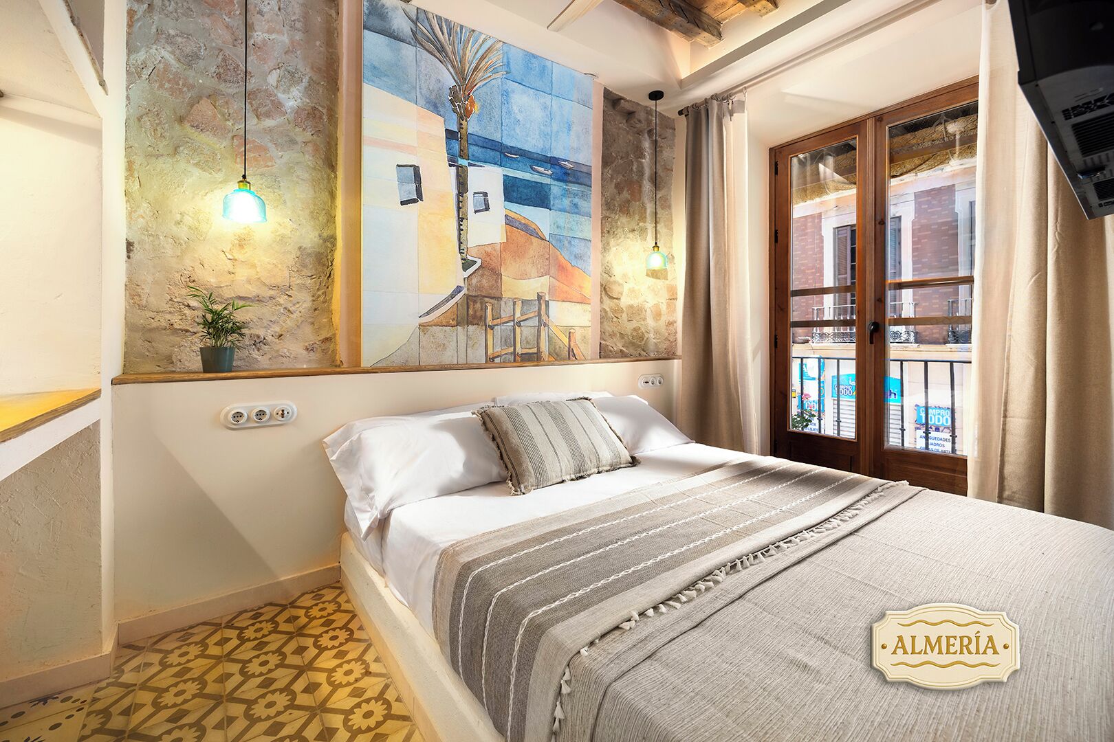 Ein Schlafzimmer mit einem Bett, einem Gemälde, einer Topfpflanze und einem Fenster mit Blick.