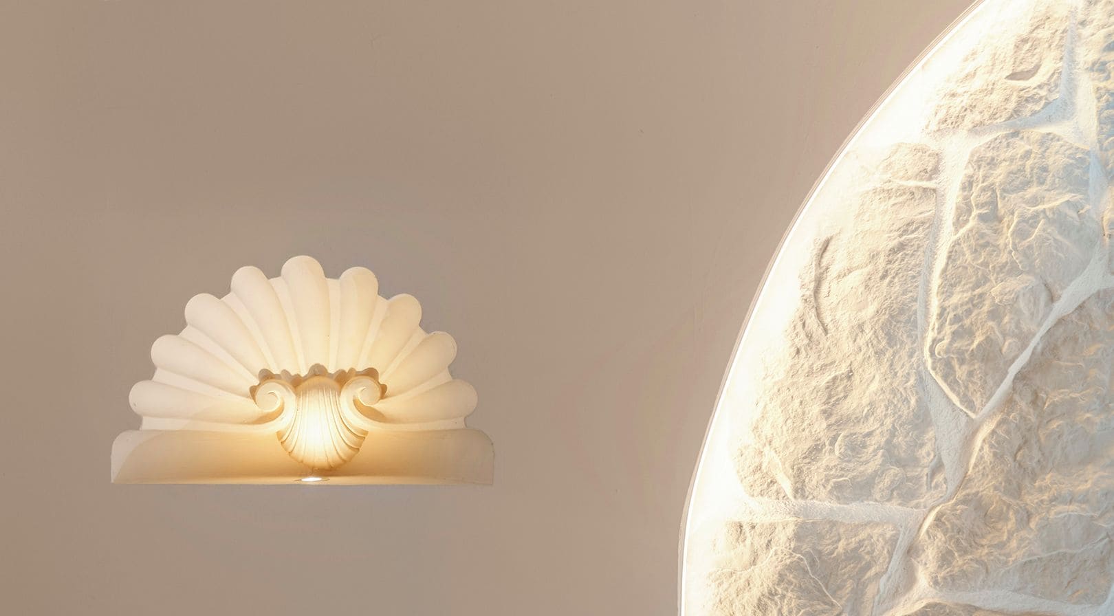 Una lámpara de pared con diseño ondulado y un letrero que dice 'HUELVA'.