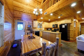L’intérieur d’un chalet en bois comprend une cuisine, un coin repas et un espace de vie.