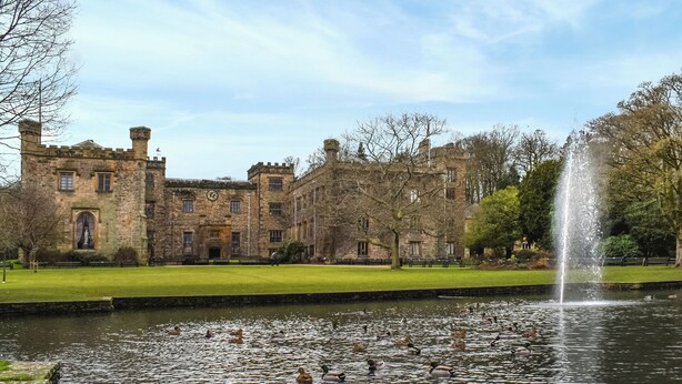 A historic stone building with a moat and fountain, surrounded by ducks and trees. - 2 bedroom accommodation in Rathmell, near Settle (Rathmell, near Settle)