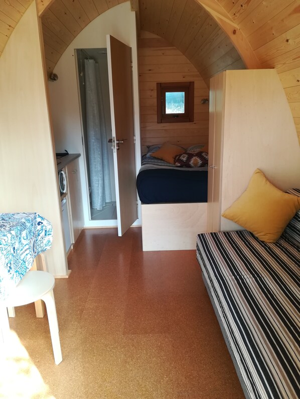 A cozy room with a bed, a small table, and a window.