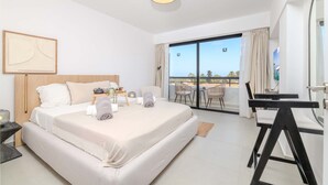 A hotel room with a large bed, a desk, and a balcony with a view. - Finikoudes Marina View 202 - Charming Larnaca Centre Getaway (Larnaca)
