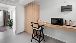 A modern kitchen with a wooden cabinet, a black chair, a microwave, a toaster, and a kettle. - Finikoudes Marina View 202 - Charming Larnaca Centre Getaway (Larnaca)