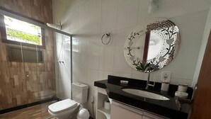 A modern bathroom with a toilet, sink, and shower. - Charming Refuge: Arraial House (Arraial d'Ajuda)