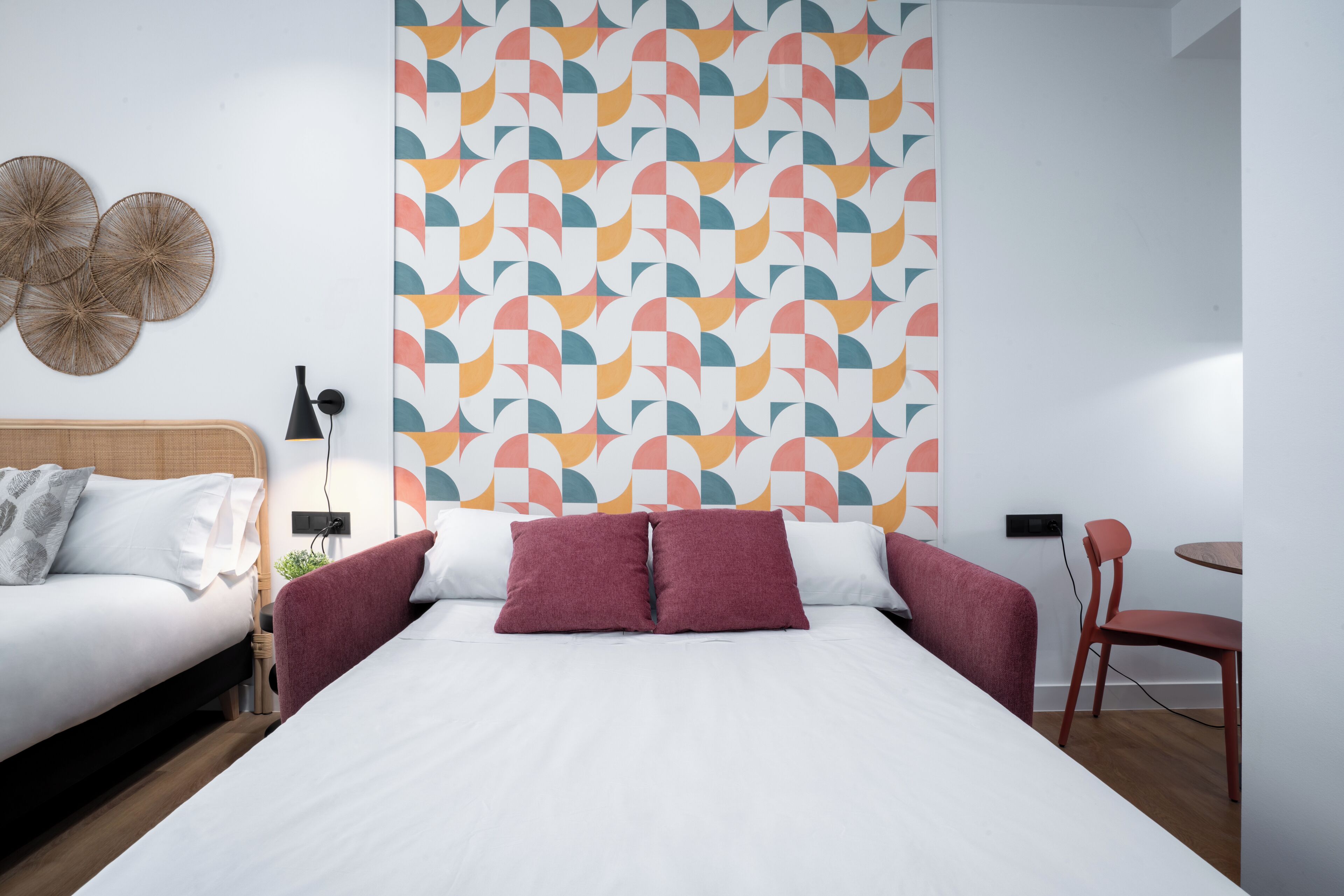 Une chambre d’hôtel moderne avec un grand lit, un petit bureau et une chaise.