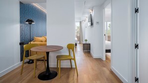 Ein modernes Interieur mit Essbereich, der einen runden Tisch und gelbe Stühle, eine Couch und eine Wand mit Muster beinhaltet.