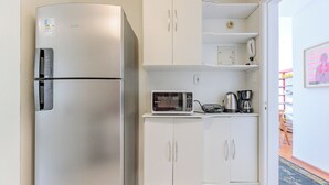 A compact kitchen with a refrigerator, microwave, and cabinets. - Vista Carioca (Rio de Janeiro)