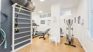 A gym with exercise equipment, a treadmill, and a wall-mounted rack with weights. - Vista Carioca (Rio de Janeiro)