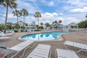 A swimming pool with lounge chairs, palm trees, and a white fence. - Lazy Magnolia * Pet Friendly & Beach Chair Set * OCTOBER DATES REDUCED (Destin)
