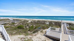 A beach view with a wooden boardwalk and a sign indicating 'Beach Access'. - 4 BR Oceanfront Carolina Clipper East has Updated Kitchen with OF Views (Emerald Isle)