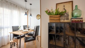 Comedor con mesa de madera, sillas negras y lámpara colgante.