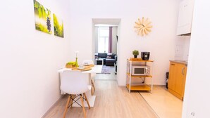 A compact living space with a dining area, kitchenette, and a view into the living room.