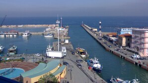 A harbor with boats, a pier, and buildings along the waterfront.