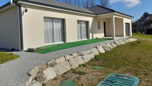 Een modern huis met een plat dak, grote schuifpuien en een klein portaal.