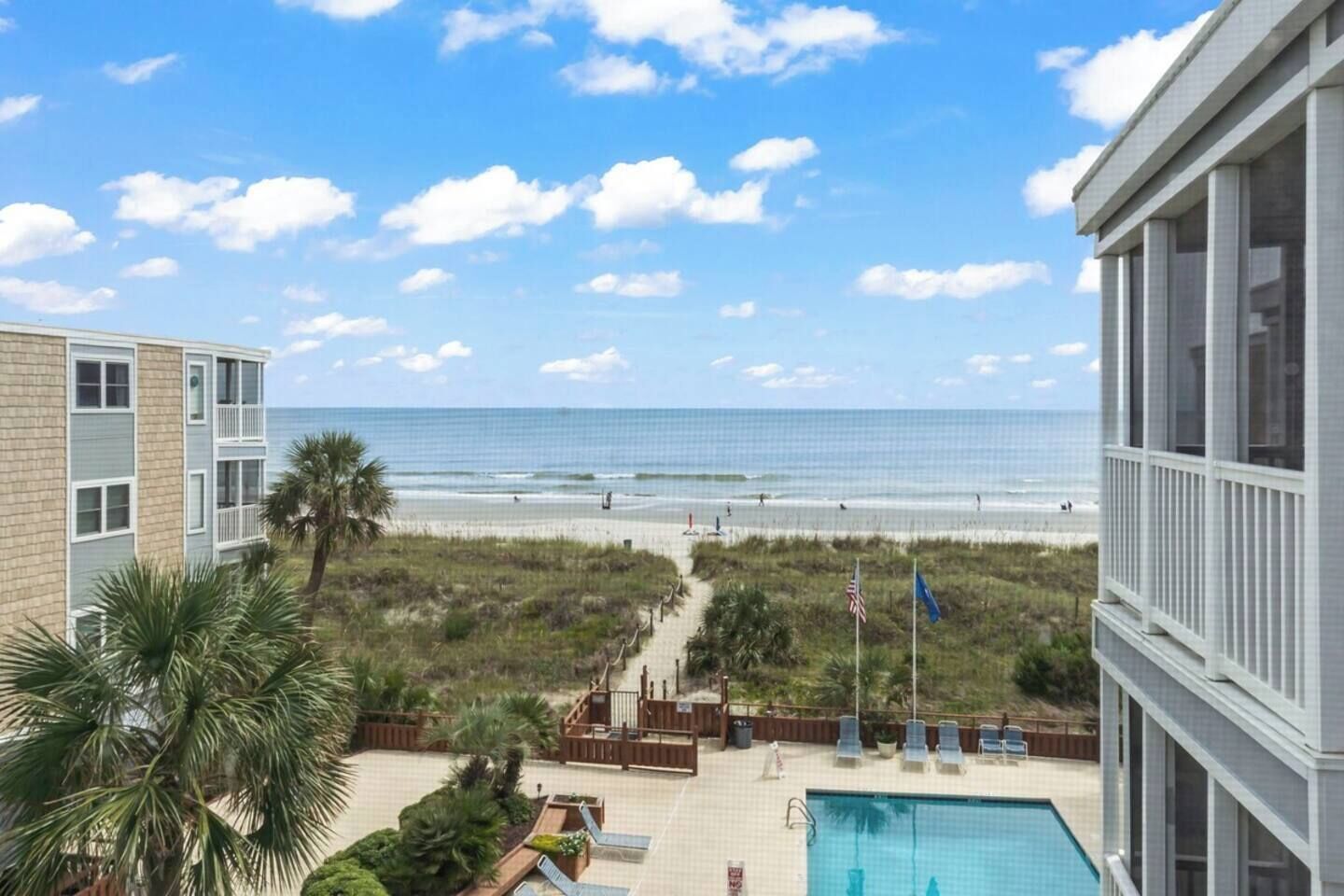 Ein Strandhotel mit Pool, Blick auf den Strand und einem Weg zum Strand.