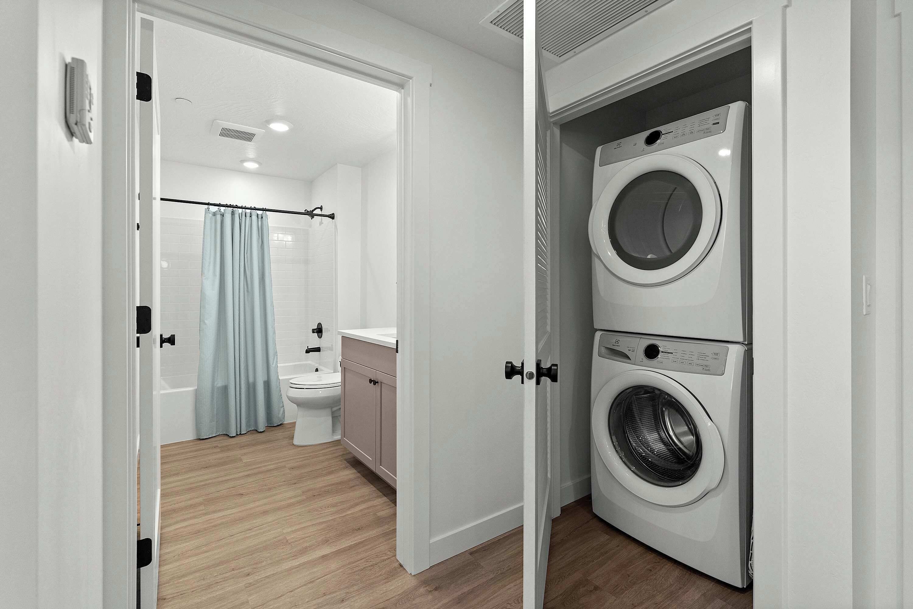 Un baño moderno con inodoro, lavamanos y cortina de ducha.