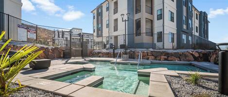 A modern building with a pool area, including a hot tub and a small rectangular pool.