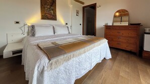 Un dormitorio con cama, cómoda de madera y un cuadro en la pared.