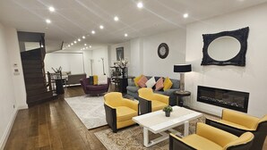 Un salon spacieux doté d’un parquet, d’une table basse centrale et d’un ensemble de canapés.