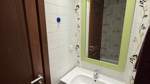A bathroom with a white sink, green-tiled walls, and a wooden door. -  apartment in fabulous Tunis with AC, WiFi (Tunis)