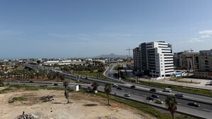 A multi-level building with a modern design, surrounded by a highway and a clear sky. -  apartment in fabulous Tunis with AC, WiFi (Tunis)