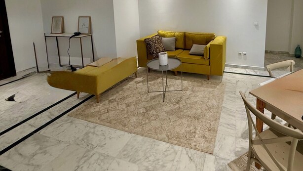 A modern living room with a yellow sofa, a small round table, and a bench. -  apartment in fabulous Tunis with AC, WiFi (Tunis)
