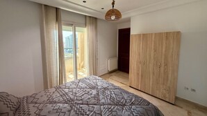 A bedroom with a bed, a wardrobe, a radiator, and a view of the outside. -  apartment in fabulous Tunis with AC, WiFi (Tunis)