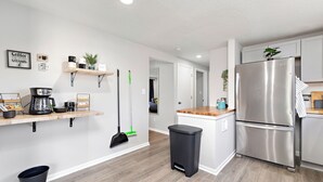 A modern kitchen with a stainless steel refrigerator, wooden countertops, and a coffee station. - Overland Park 4BR Home 2 Kings Garage Dog Friendly (Overland Park)