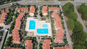 An aerial view of a residential area with multiple houses, a central swimming pool, and a road. - Family Vacation Apartment With Swimming Pools (San Michele al Tagliamento)