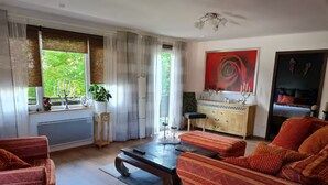 A living room with a sofa set, a coffee table, and a cabinet with decorative items. - Holiday cottage near Passau /Pullman City (Windorf)
