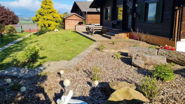 A wooden cabin with a well-maintained lawn and garden. - Holiday cottage near Passau /Pullman City (Windorf)