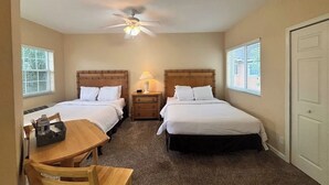 A bedroom with two beds, a ceiling fan, a table with chairs, and a window. - Right Direction Rentals Studio Villa 8229 (Port St. Lucie)