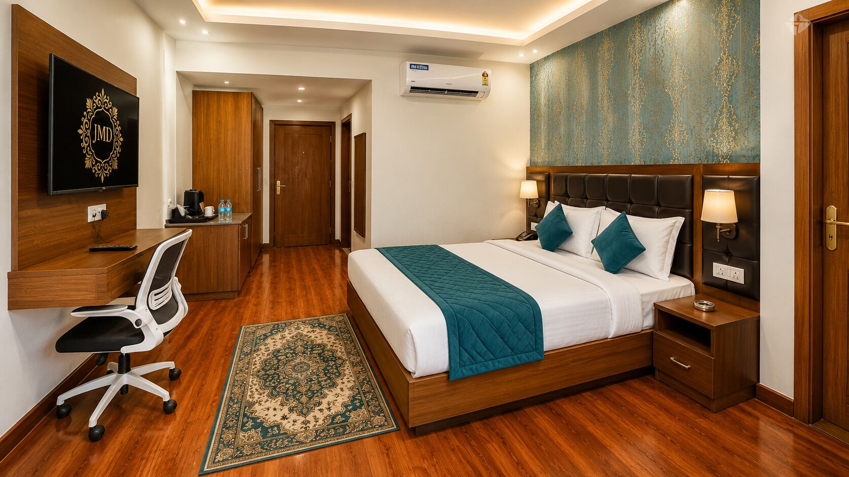 Una habitación de hotel con cama, mesitas de noche, escritorio, silla, televisor y aire acondicionado.