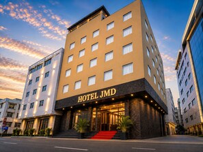 A modern hotel building with a prominent entrance and multiple floors. - Hotel JMD - Managed by Kian (New Delhi)