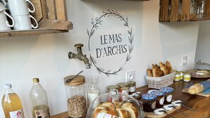A rustic wooden bar with various food items, jars, and glassware. - Le Mas d'Archas (Allan)