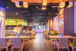 Et restaurantinteriør med flere borde og stole, en disk med en menu og en væg med et skilt.