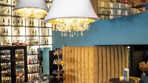 A bar area with a sofa, chairs, and a bar counter. - Aiola Living Boutique Hotel Graz (Graz)