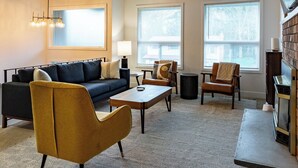 A modern living room with a sofa, armchairs, a coffee table, and a TV stand. - Sauna, Beach, Sunset, Game Room, Peace and Quiet, Fun! (Oak Harbor)