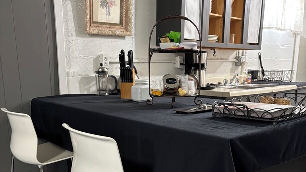 Una cocina moderna con una isla central, taburetes de bar y una cafetera.