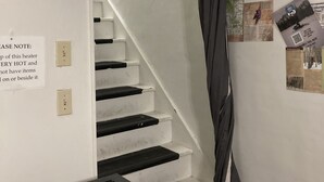 Una escalera con un cartel de precaución sobre la temperatura del calentador.