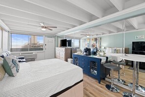 A bedroom with a bed, a desk, a chair, a television, and a window. - Beachfront Studio, Sleeps 2, Pool (Panama City Beach)