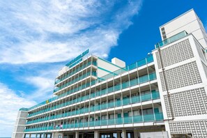 A multi-story hotel with a modern architectural design, featuring balconies and a clear sky. - Beachfront Studio, Sleeps 2, Pool (Panama City Beach)