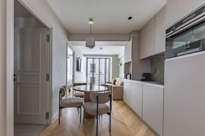 Una cocina moderna con comedor, horno Siemens y vistas al exterior.